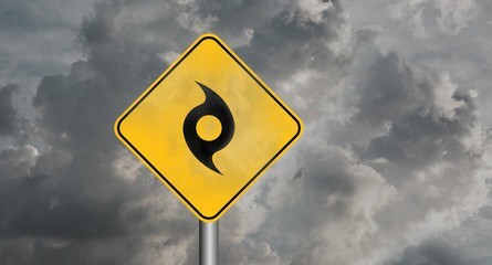 Gray storm clouds with a hurricane symbol on a yellow sign.