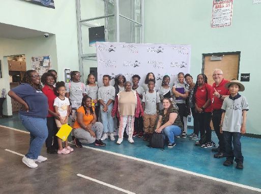 A big group standing in front of a backdrop for a group photo.